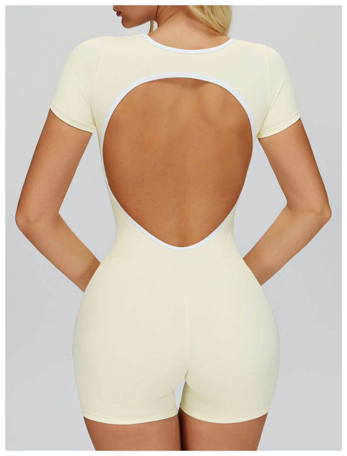 Additional view of the cream EVL short jumpsuit with an oval back cut-out.