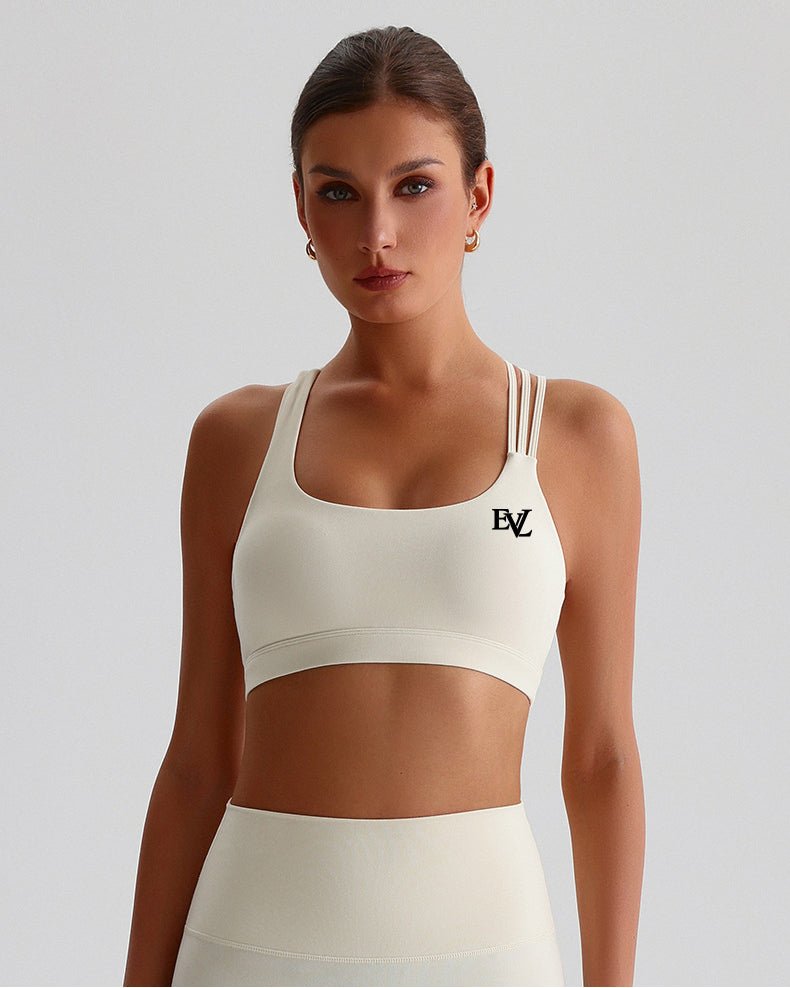 Cream EVL sports bra with a scoop neckline and contrasting chest logo.