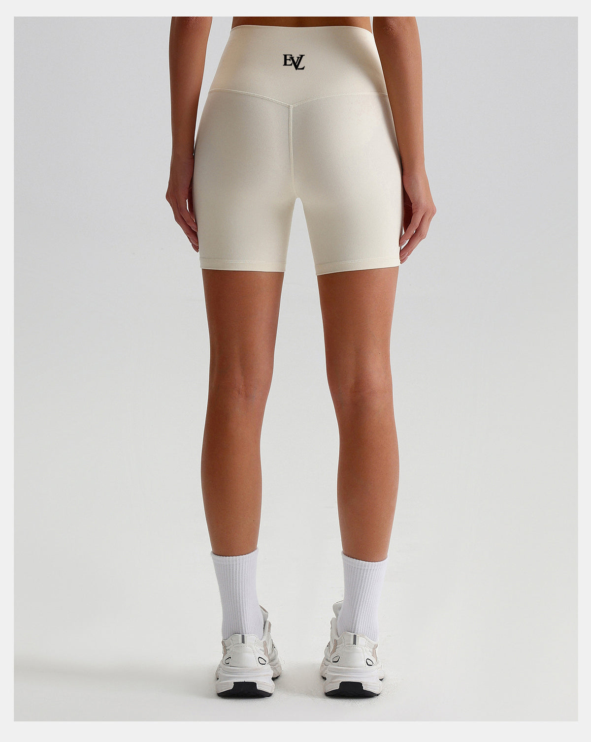 Additional view of cream EVL cycling shorts with a wide waistband.