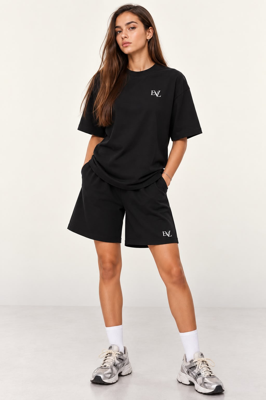 Model wearing the black EVL unisex oversized T-shirt and matching shorts.